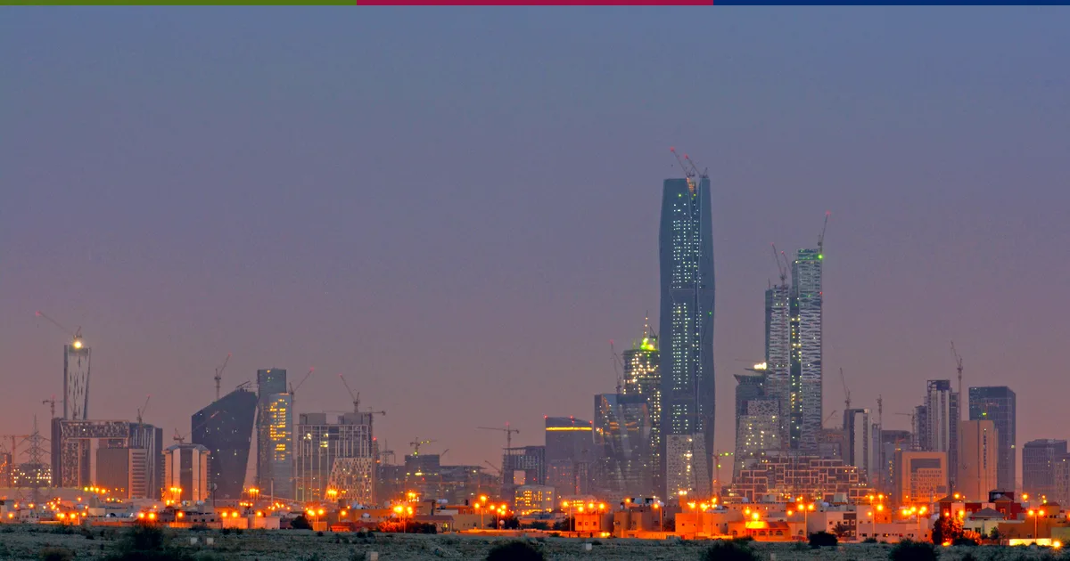 حي الملك عبدالله المالي في الرياض عند الغروب، وأبراجه مضاءة أمام سماء وردية