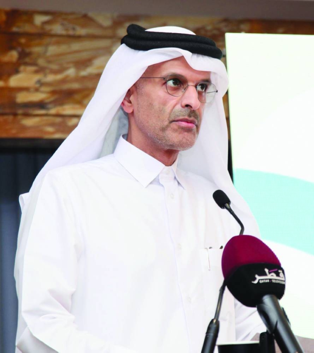 A speaker in white thobe and black agal addressing the audience from the lectern at the Second Conference on ESG Qatar.