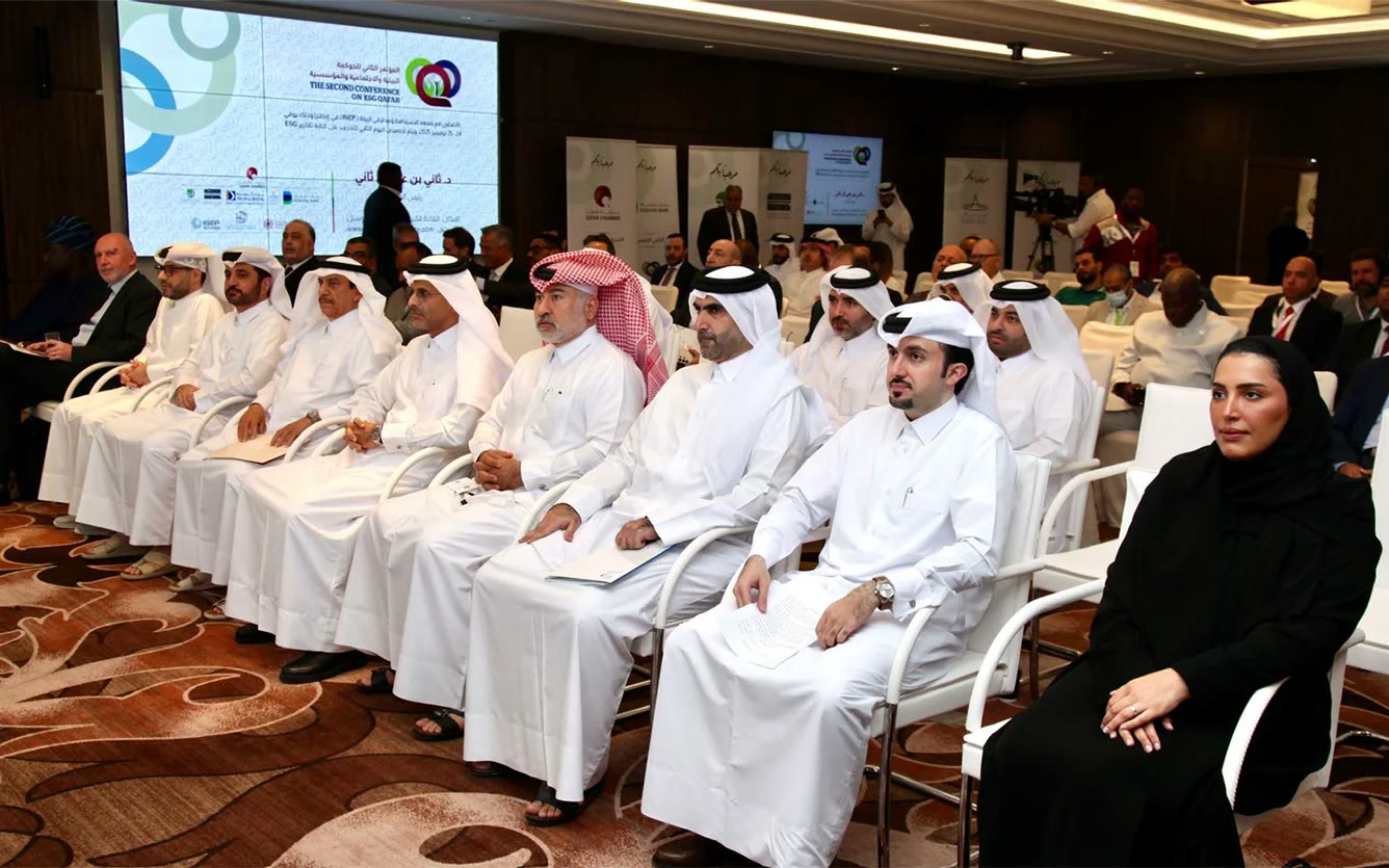 Wide view of the ESG Qatar 2025 conference hall, with seated attendees, sponsor banners and the branded main screen.